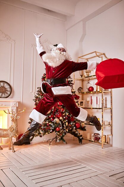 큰 빨간 선물 가방을 든 산타 클로스는 아이들에게 선물을 가져 오기 위해 서두 릅니다. 메리 크리스마스, 해피 홀리데이 개념