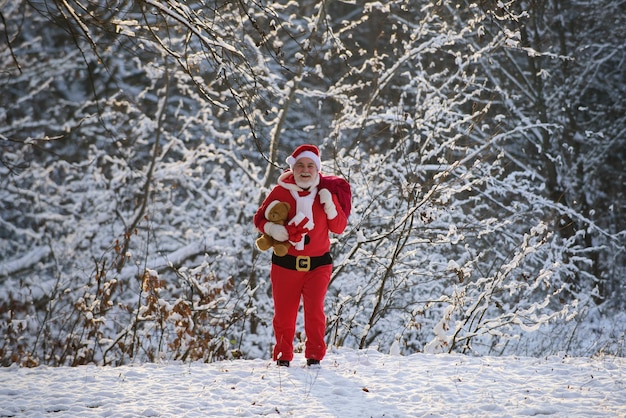 Санта-клаус с рождественским подарком в снегу
