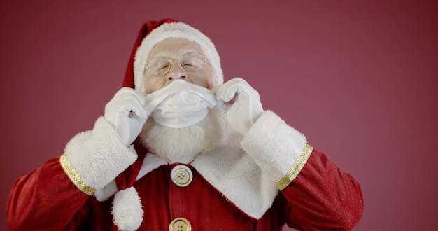 Foto babbo natale con covid-19, che indossa una maschera protettiva. natale 2020. pandemia