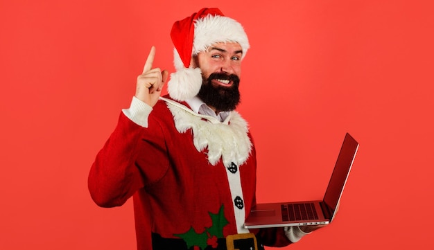 Santa claus with laptop bearded businessman in santa costume with computer pointing up online