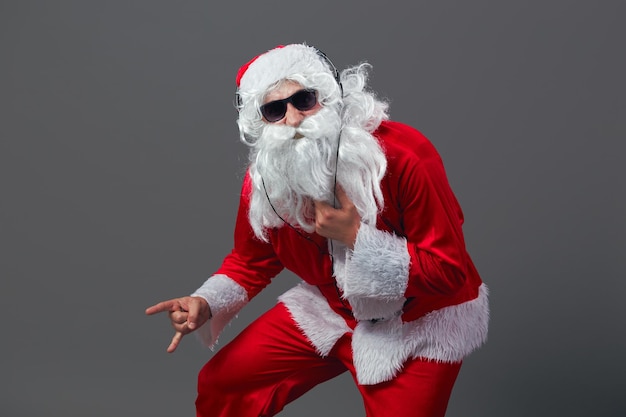 Santa Claus with a long white beard and in sunglasses and headphones