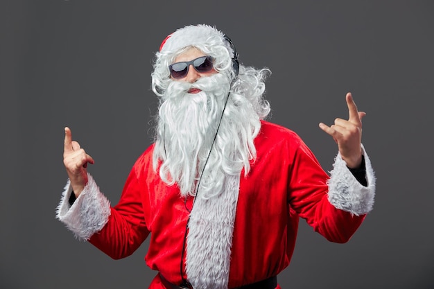 Babbo natale con una lunga barba bianca e occhiali da sole e cuffie