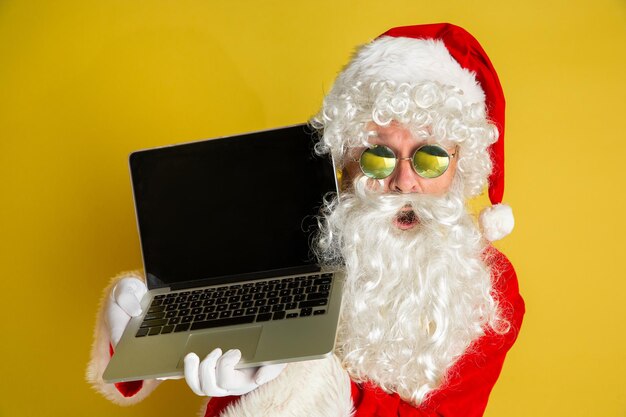 Babbo natale con occhiali moderni isolati su sfondo giallo studio