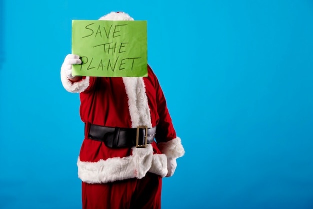 Foto babbo natale con un poster di salvare il pianeta su sfondo blu