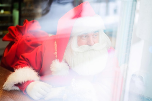 Photo santa clause looking through window