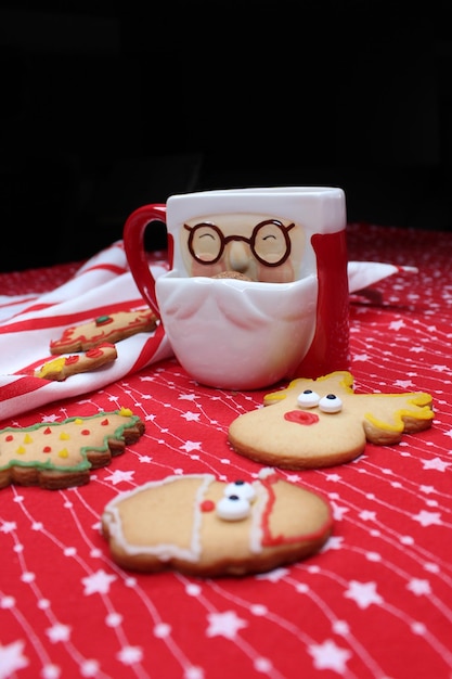 Foto una tazza a forma di babbo natale con cioccolato caldo o caffè i biscotti di natale spuntano dalla tazza