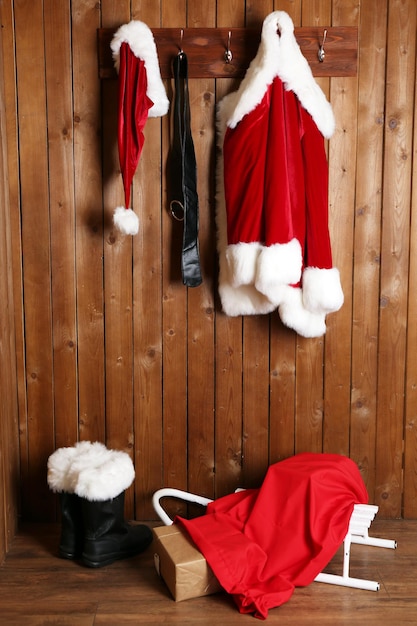 Foto costume da babbo natale appeso sullo sfondo della parete in legno