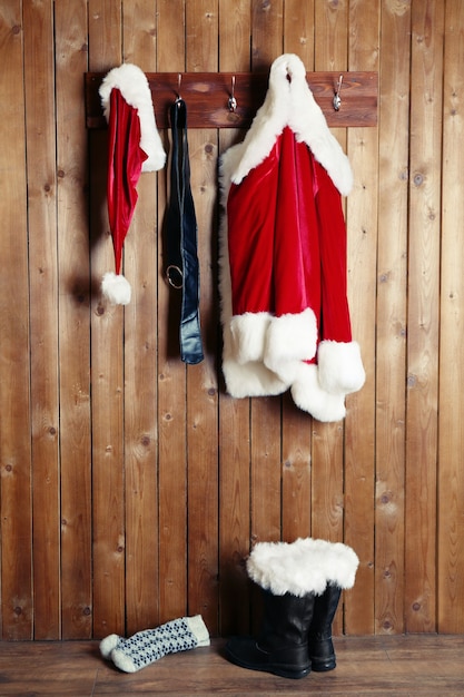 Santa costume hanging on wooden wall background