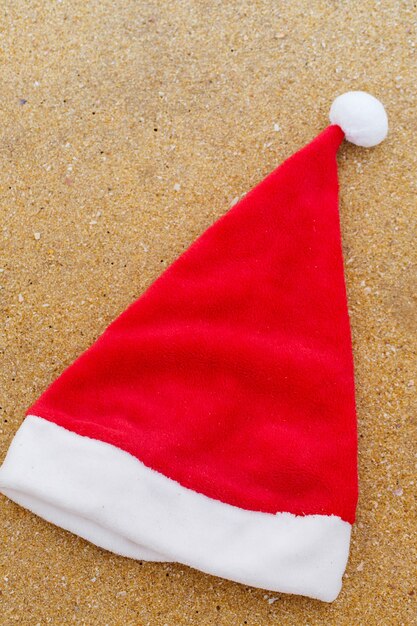 Photo santa hat on the sandy beach