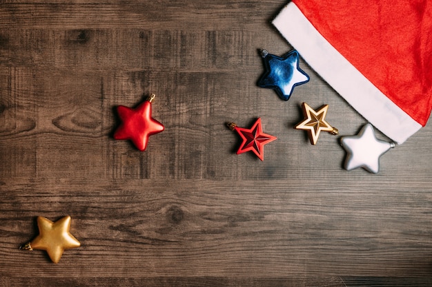 Santa hat with metallic stars on wooden background. Flat lay for Christmas and happy new y