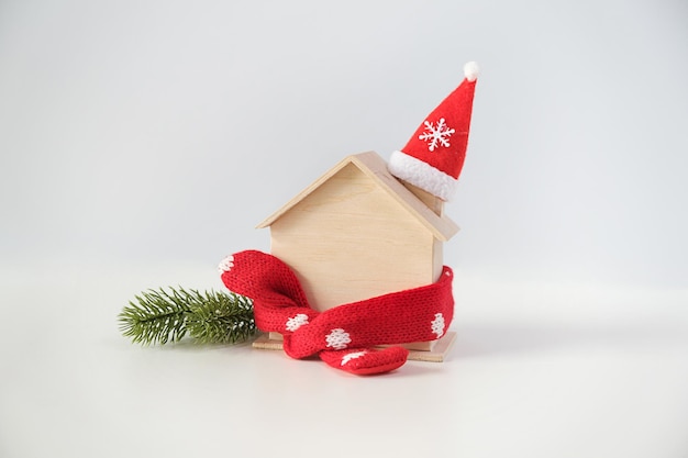 Santa hat with miniature house model over blank chalkboard