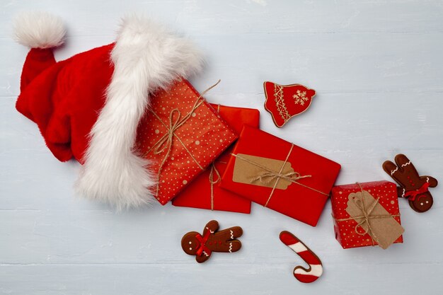 Santa hat and wrapped gift boxes top view flat lay