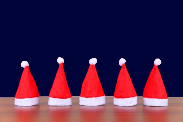 Santa hats on table against blue background