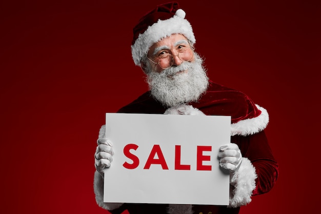 Photo santa holding christmas sale sign