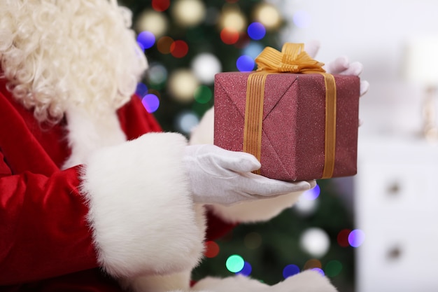 Santa holding gift on Christmas tree