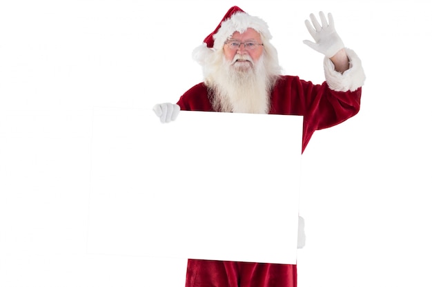 Santa holds a sign and is waving