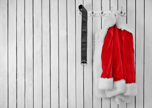 Santa jacket and belt on a wooden white wall