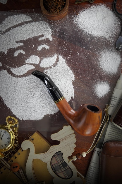 Santa made of snow spray smoking pipe on wooden desk