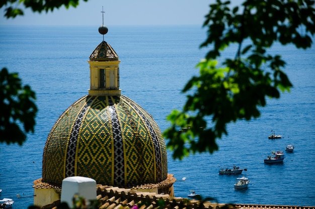 Photo santa maria assunta church in positano - detail of the dome against the sea