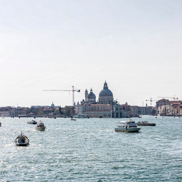 Santa Maria della Salute basilica with civil traffic and city skyline in summer Venice