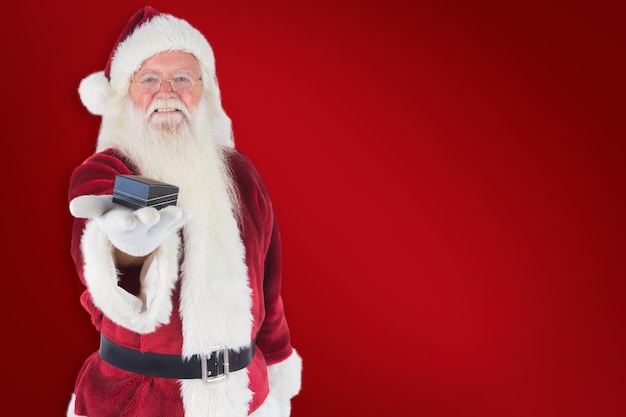 Santa shows a little box against red background