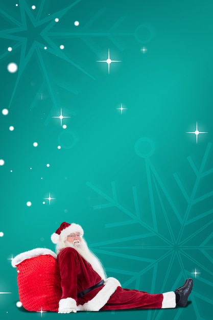 Santa sits leaned on his bag against green snowflake background