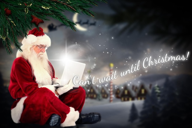 Santa sits and uses a laptop against santa delivery presents to village