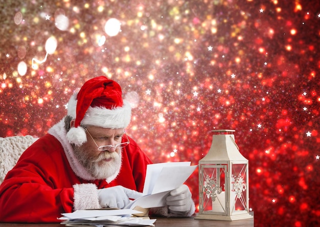 테이블에 앉아서 크리스마스 편지를 읽는 산타
