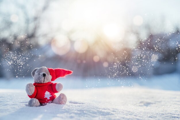 雪のクリスマスと新年の背景にサンタのテディベア