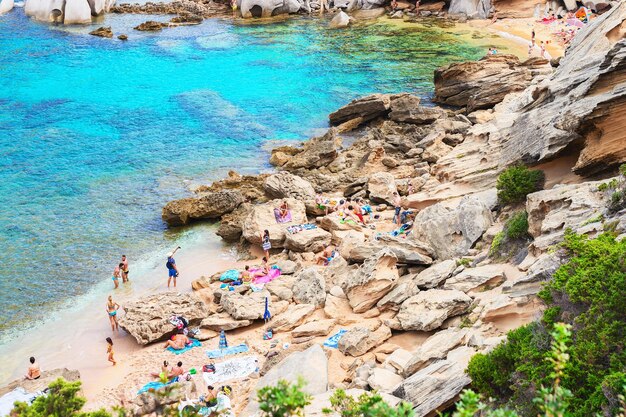 Photo santa teresa gallura, italy - september 9, 2017: people on the beach at the mediterranean sea in capo testo, santa teresa gallura, sardinia, italy