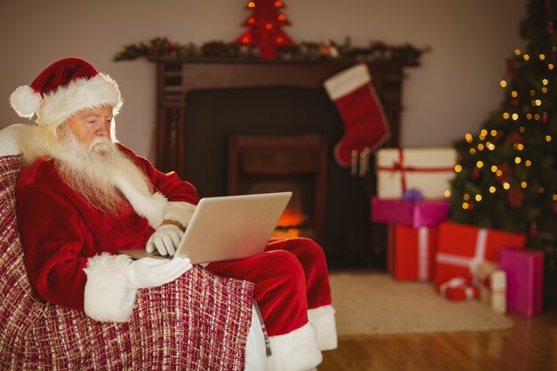 Santa using laptop on the couch at christmas