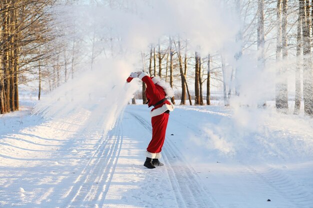 Santa in the winter field. Santa magical fog walking along the field. Santa on Christmas Eve is carrying presents to children in a red bag