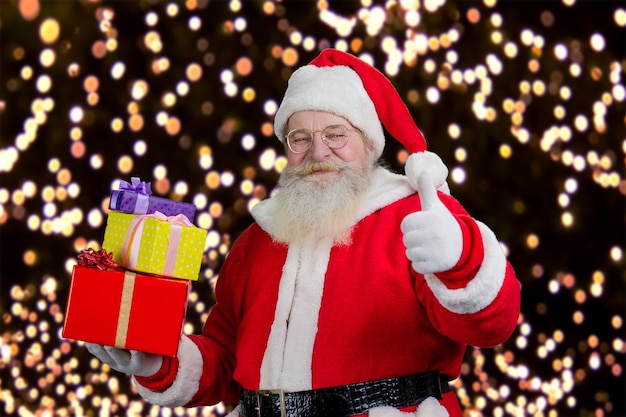 Santa with gifts showing thumb up.