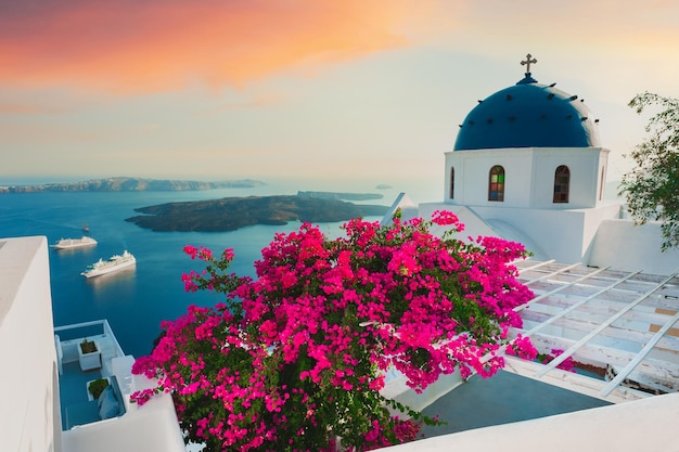 Santorini eiland Griekenland Witte architectuur met roze bloemen bij zonsondergang