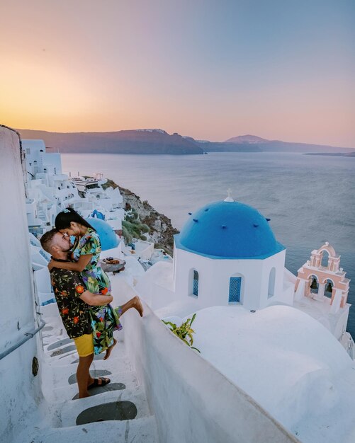 Santorini greece couple mid age european and asian on vacation at the greek village oia santorini