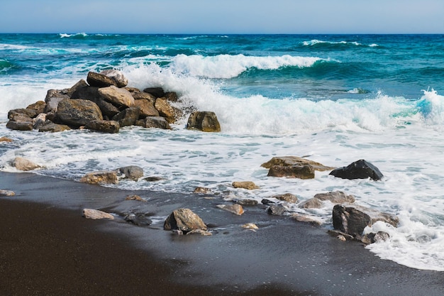 Santorini island Greece Waves on the Perissa beach with black volcanic sand