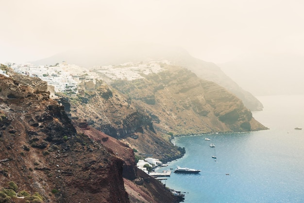 Santorini island in the morning fog, Greece. Summer landscape, sea view