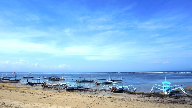 Sanur beach bali con sabbia bianca e pescatore in barca