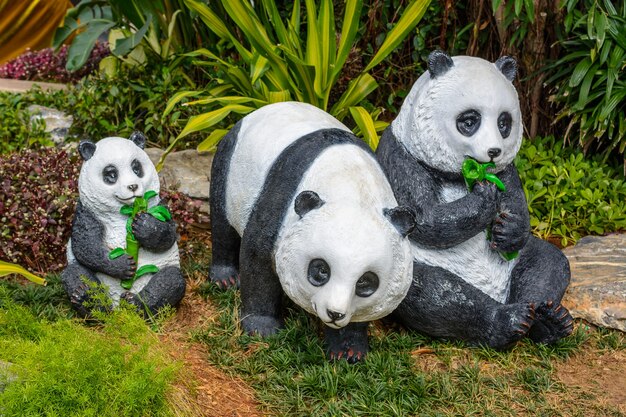 Фото Санья, хайнань, китай - 20 февраля 2020 года: красочные статуи семьи панд на улице саньи в пасмурный день.