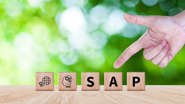 SAP システムコンセプト SAP システムアプリケーション 製品 SAP とデジタル変革のアイコンを持つ木製のブロックは,現代のビジネス管理ソリューションを象徴しています.
