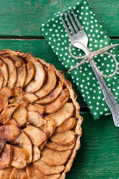 Foto sappige appeltaart met kaneel en brandewijn op een groen oppervlak