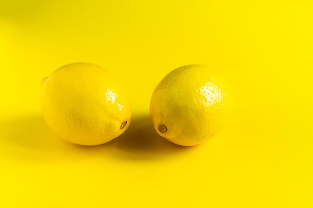 Sappige citroenen op heldere gele achtergrond, citrus minimaal concept. plat lag, bovenaanzicht, kopieer ruimte.
