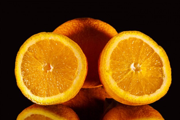 sappige gesneden sinaasappel op een zwarte achtergrond
