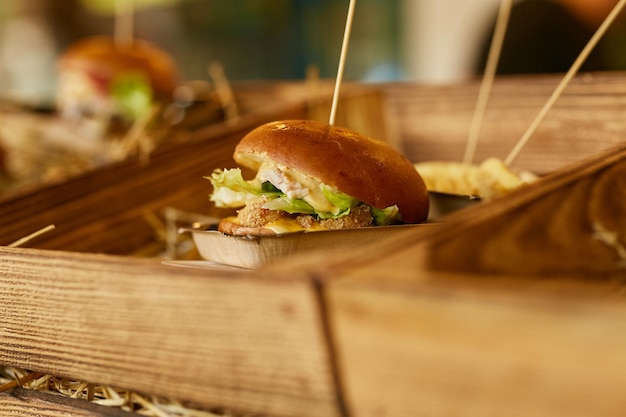 sappige hamburger met vleeskruiden en kaas ligt op de hooiburger op een bokeh-achtergrond