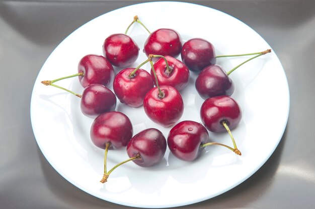 Sappige kersenbessen liggen op een witte plaat. gezond eten als ontbijt. vruchten van vegetatie. fruit dessert