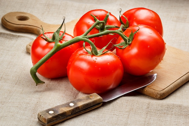 Sappige rode tomaten op een snijplank en een mes