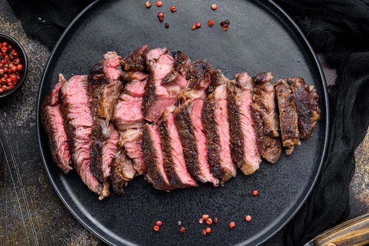 Foto sappige steak medium rare beef set, rib eye cut, op bord, bovenaanzicht plat gelegd