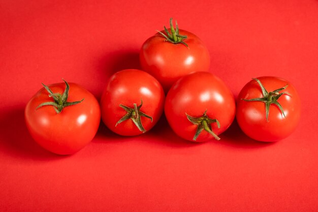 Sappige tomaten op een felrood oppervlak