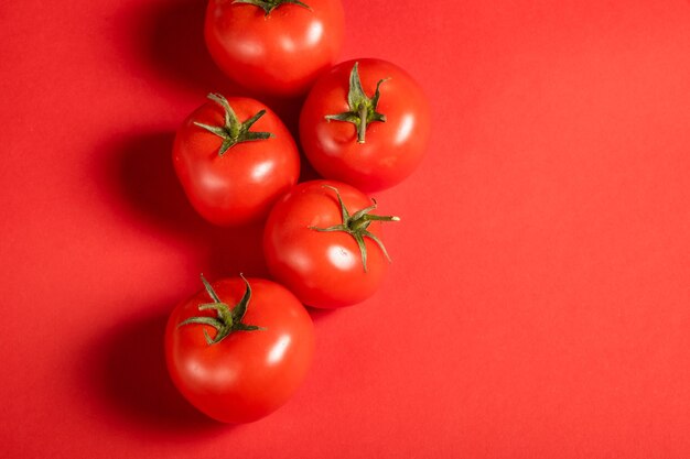 Sappige tomaten op een felrood oppervlak