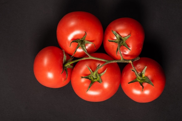 Sappige tomaten op een zwarte ondergrond